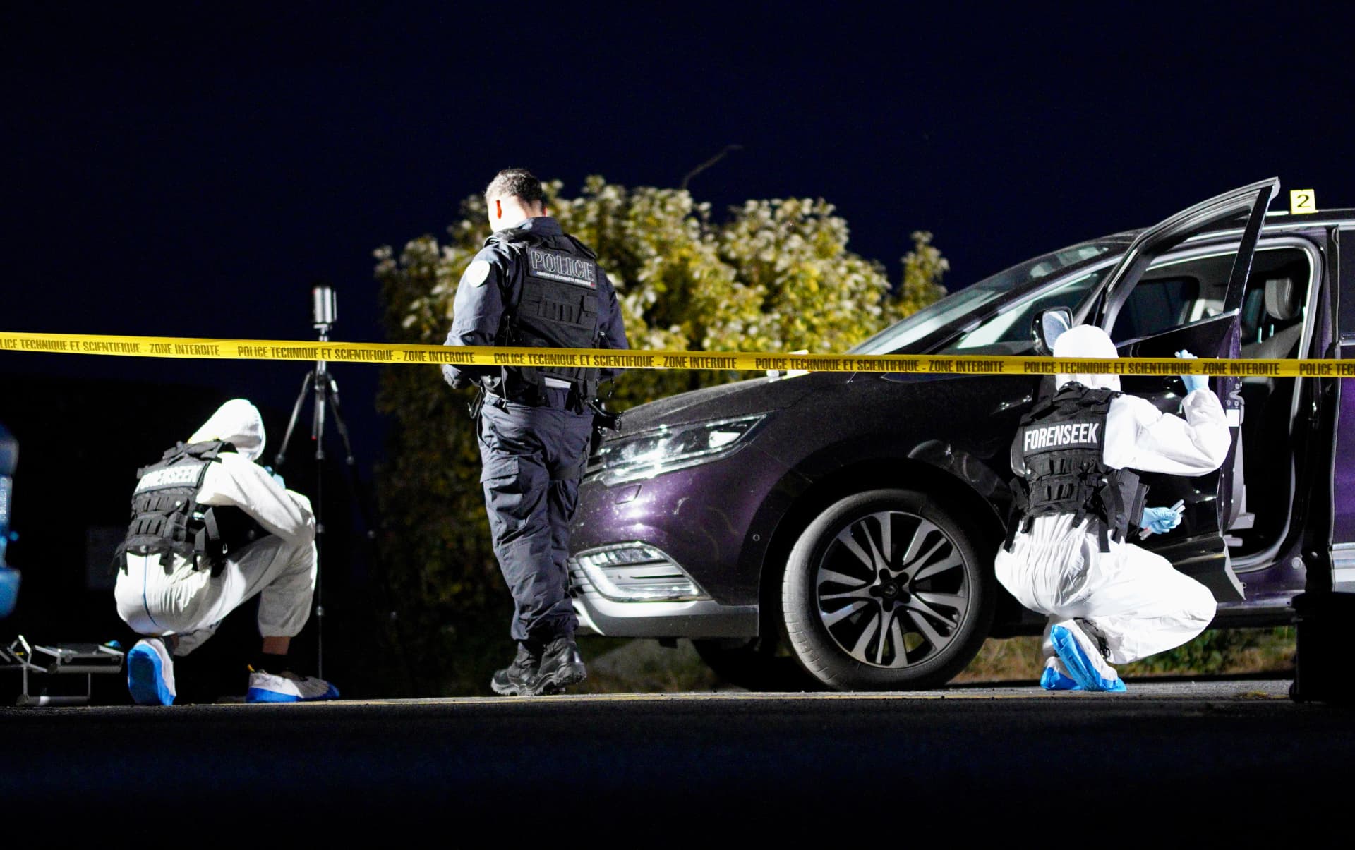 Scène de crime avec policiers scientifiques en combinaison blanche