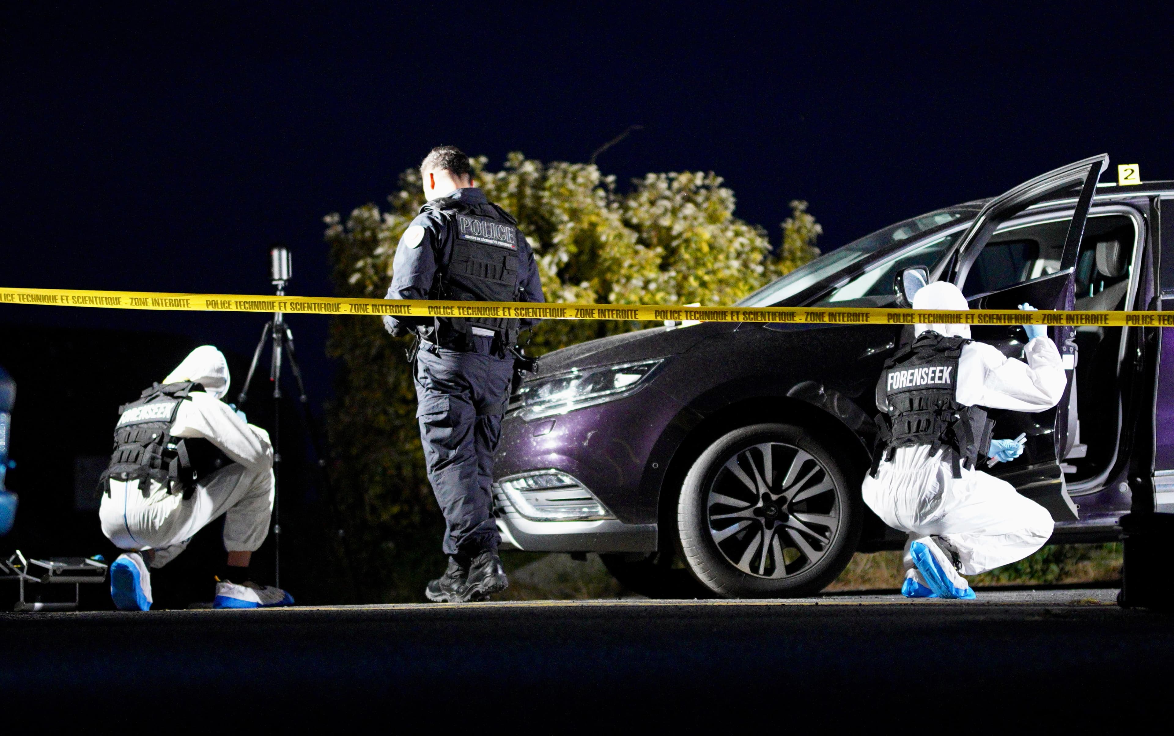 Scène de crime avec policiers scientifiques en combinaison blanche